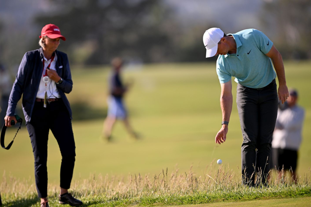 Rory McIlroy a rozhodčí Courtney Myrhum v inkriminované situaci ve finálovém kole US Open (Foto: GettyImages). Rory McIlroy a rozhodčí Courtney Myrhum v inkriminované situaci ve finálovém kole US Open (Foto: GettyImages).